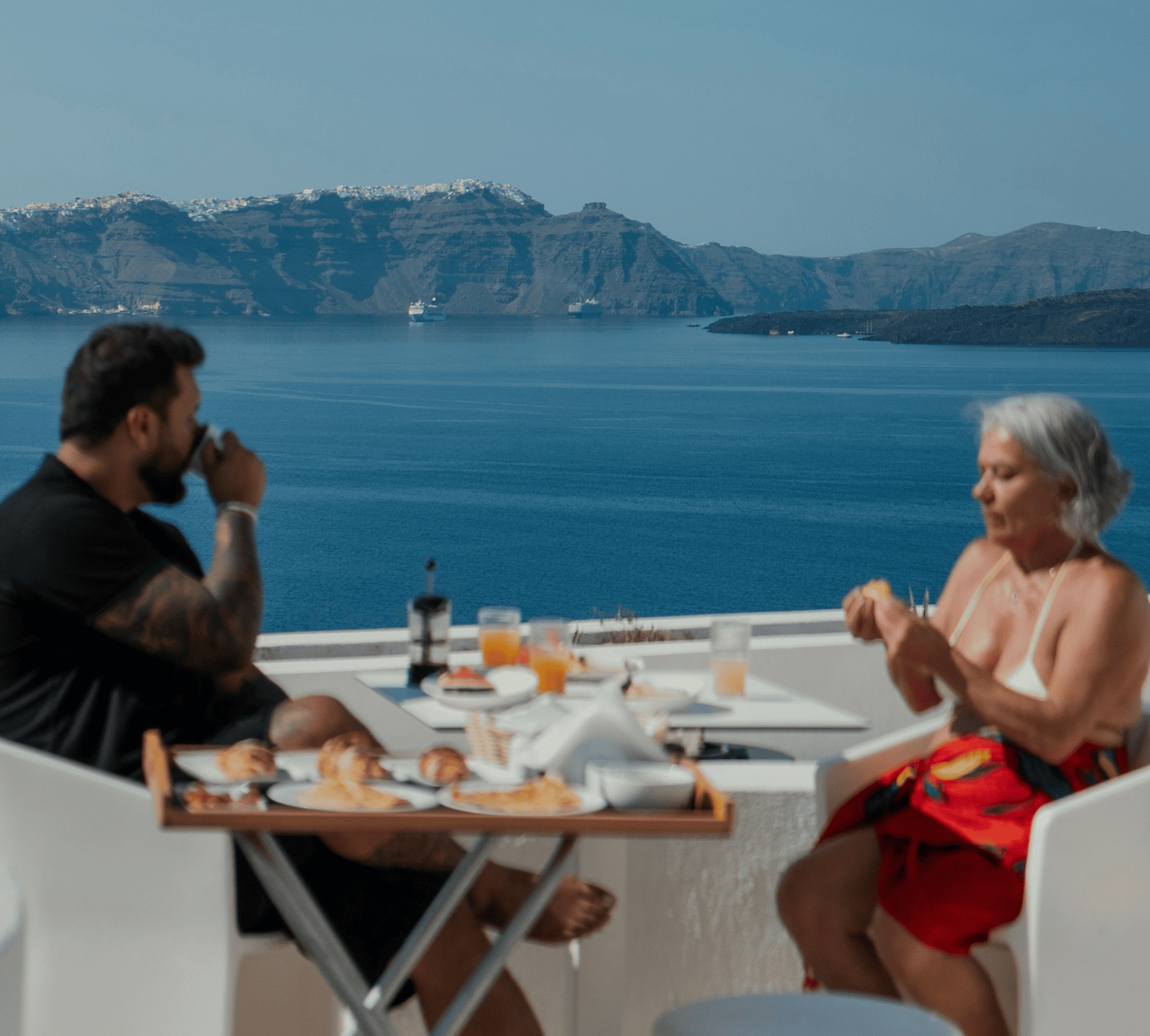 Two people enjoying a meal overlooking a lake with mountains
